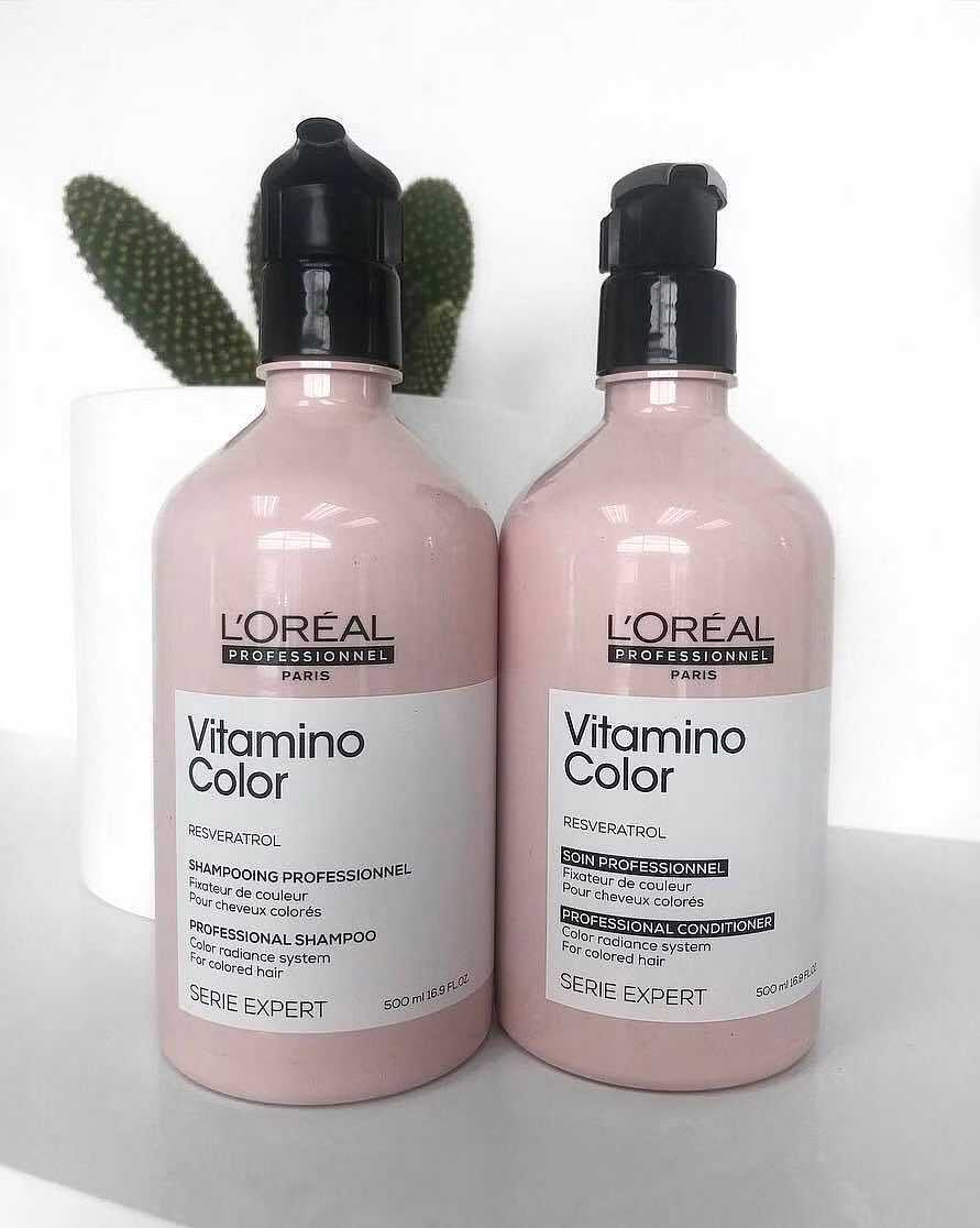 Two bottles of L'Oréal Vitamino Color shampoo and conditioner on a white surface.